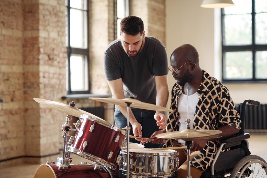 man getting taught drums